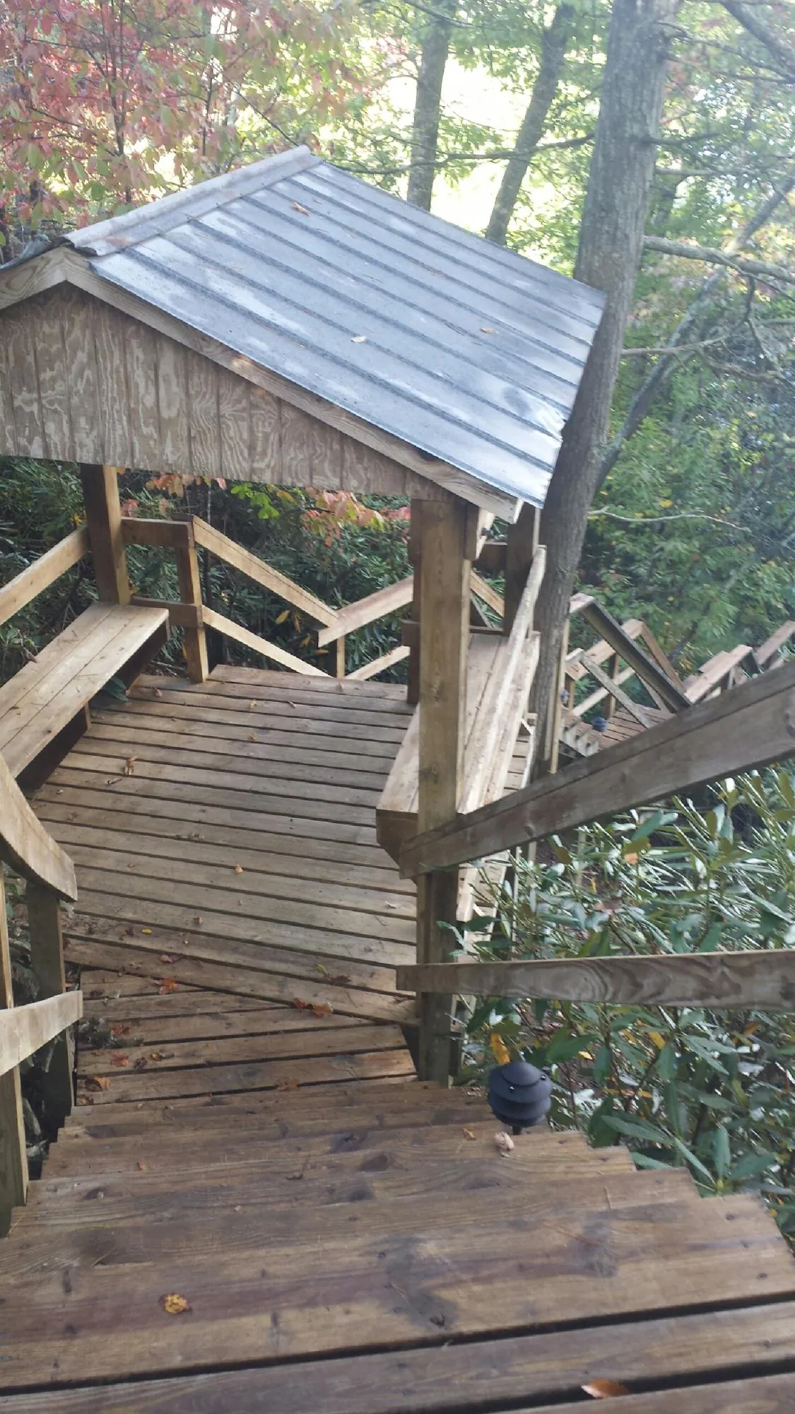 Metal roofed shelter over wooden steps on a wooded walkway — Skylight Repair & Installation work by our crew in Woodbury