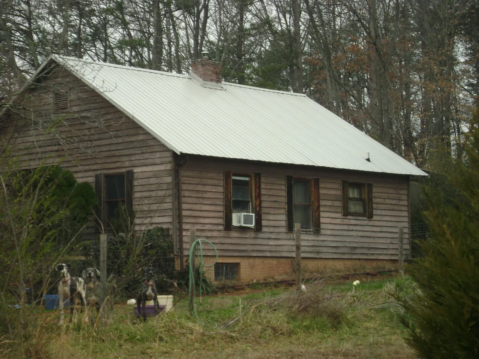 White metal roof on an old wood sided farmhouse, from a Metal Roof Installation job in Woodbury
